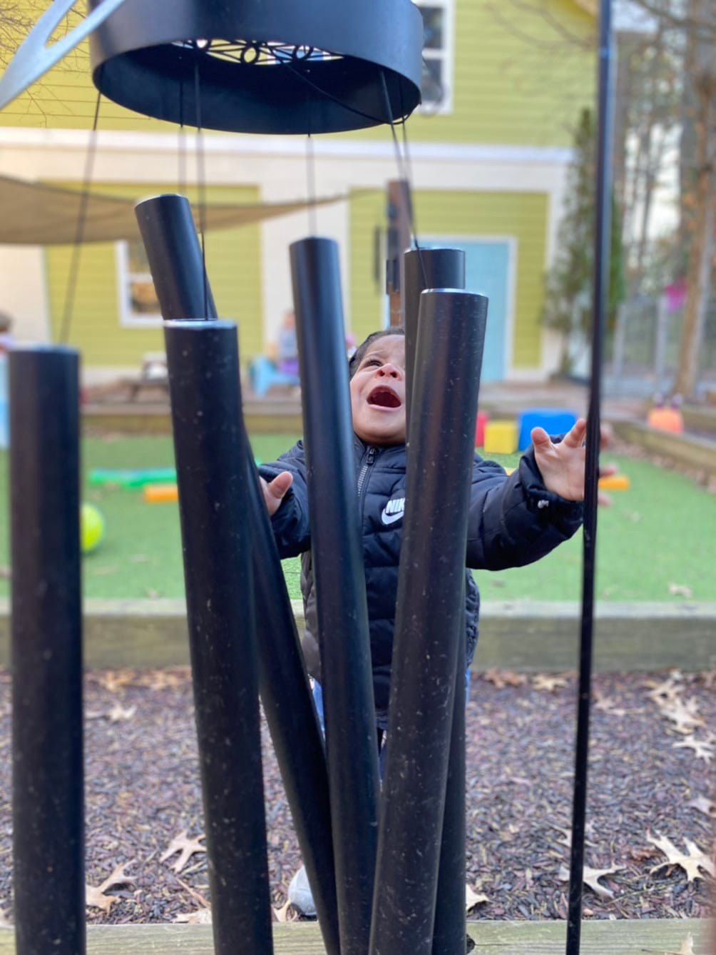 toddler playing with wind chimes